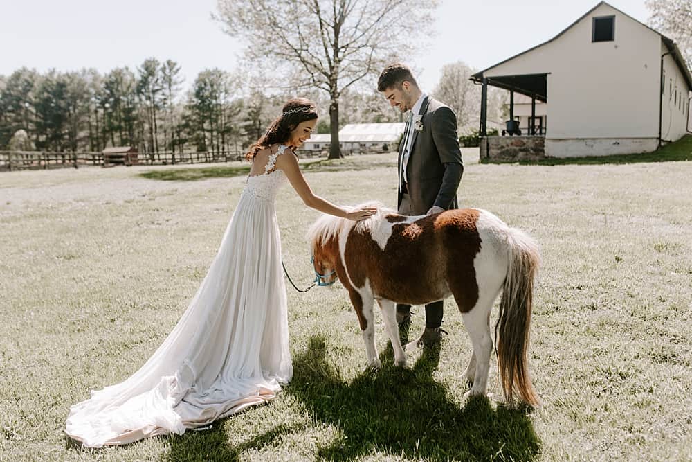 bride playing with pony on her wedding day