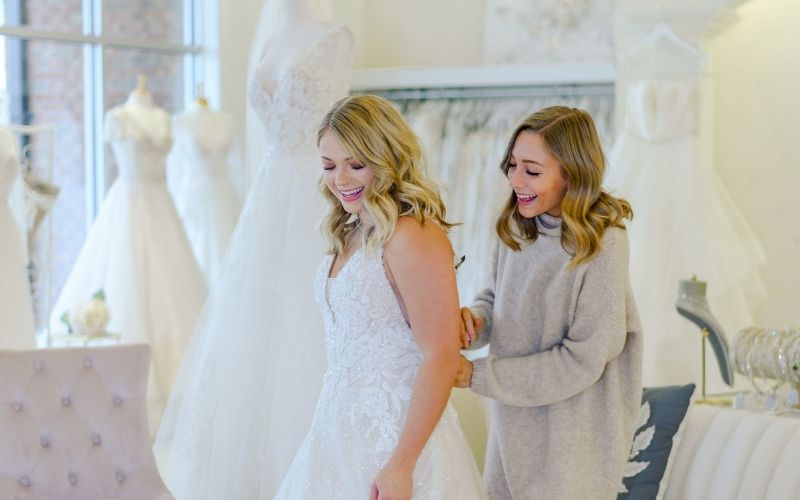 Bride-to-be exploring wedding dress options at Ashley Grace Bridal in Lynchburg, VA, guided by a personal stylist during her wedding planning journey