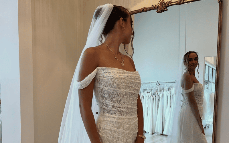 bride looking at her wedding dress in the mirror